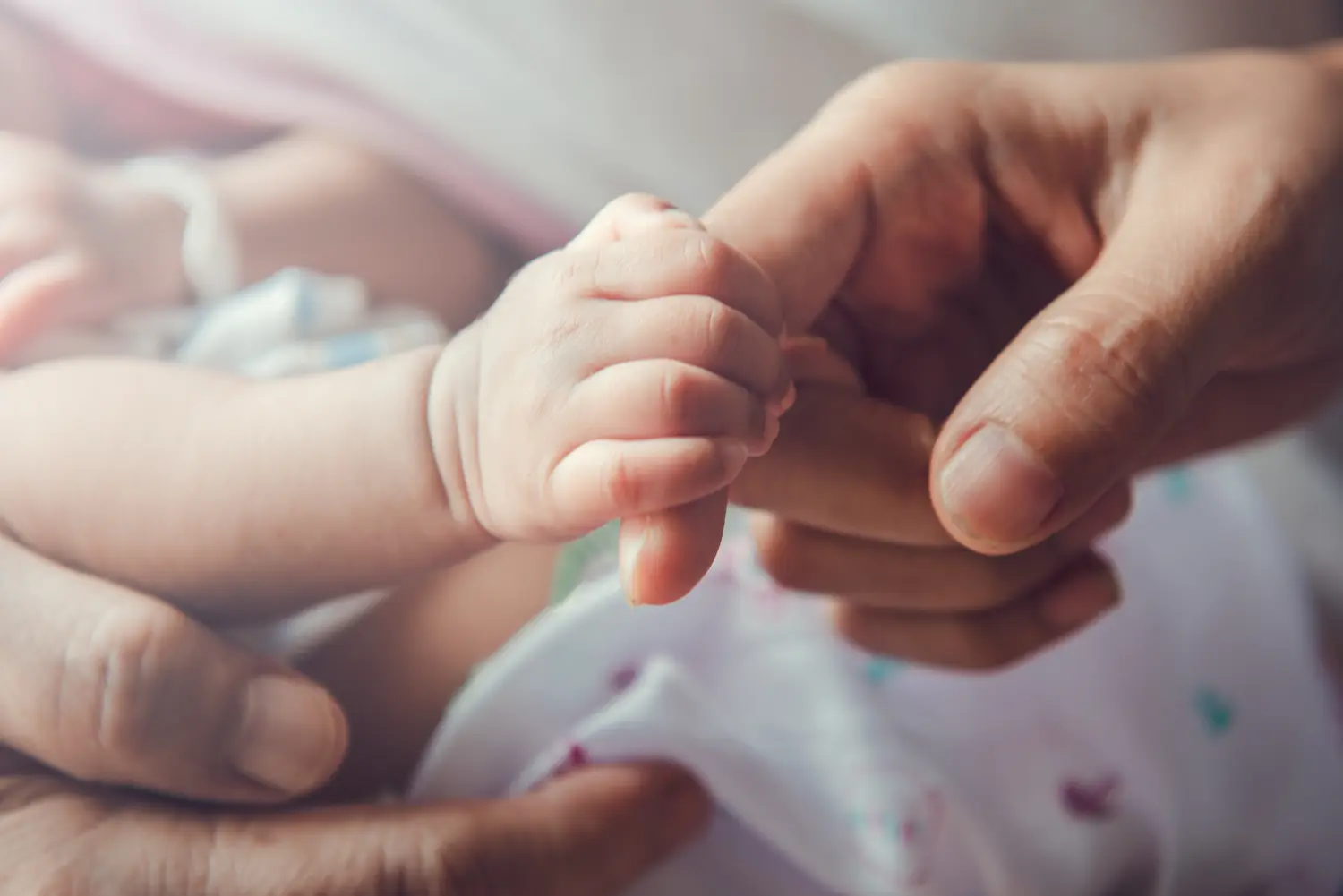 Neugeborenes Baby hält die Hand der Mutter.